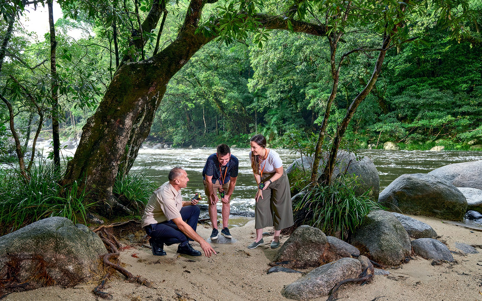 Visitors exploring Mossman Gorge in Daintree National Park by a riverbank.