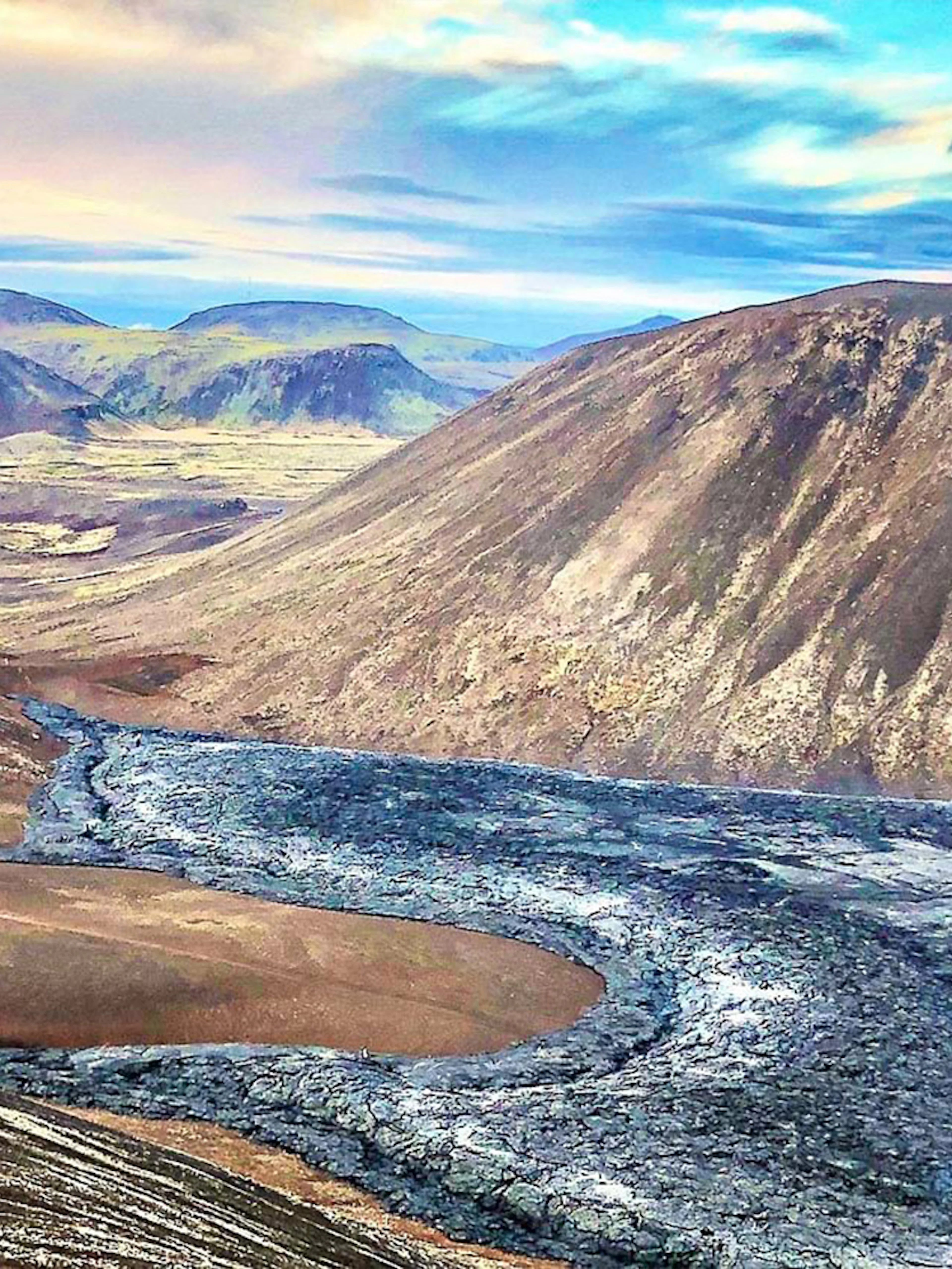 Volcanic landscape in Reykjanes, Iceland, with lava fields and distant hills.