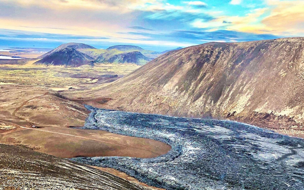 Volcanic landscape in Reykjanes, Iceland, with lava fields and distant hills.