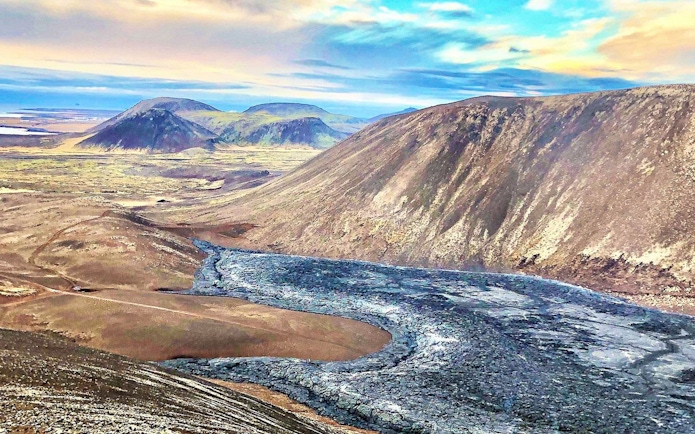 Volcanic landscape in Reykjanes, Iceland, with lava fields and distant hills.