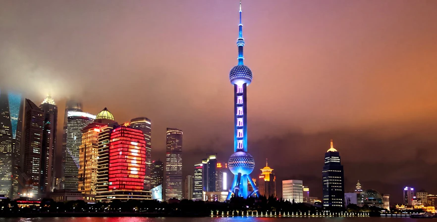 Cruise on Huangpu River past Shanghai skyline with Oriental Pearl Tower illuminated.