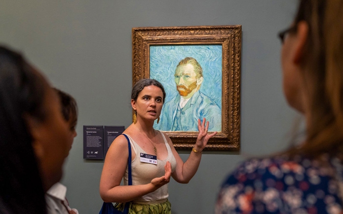 Tour guide explaining Van Gogh painting at Musée d’Orsay, Paris.