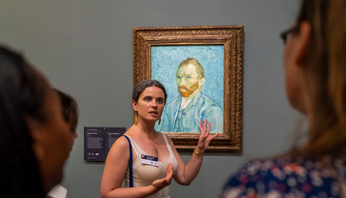 Visitors viewing Impressionist art at Musée d’Orsay, Paris, with gourmet lunch experience.