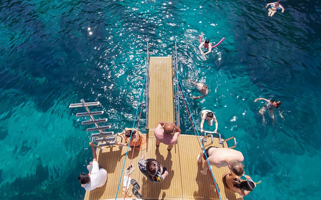 People enjoying a swim off a cruise deck at the Blue Lagoon.
