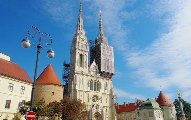 Zagreb Cathedral with scaffolding on a sunny day during a walking tour.