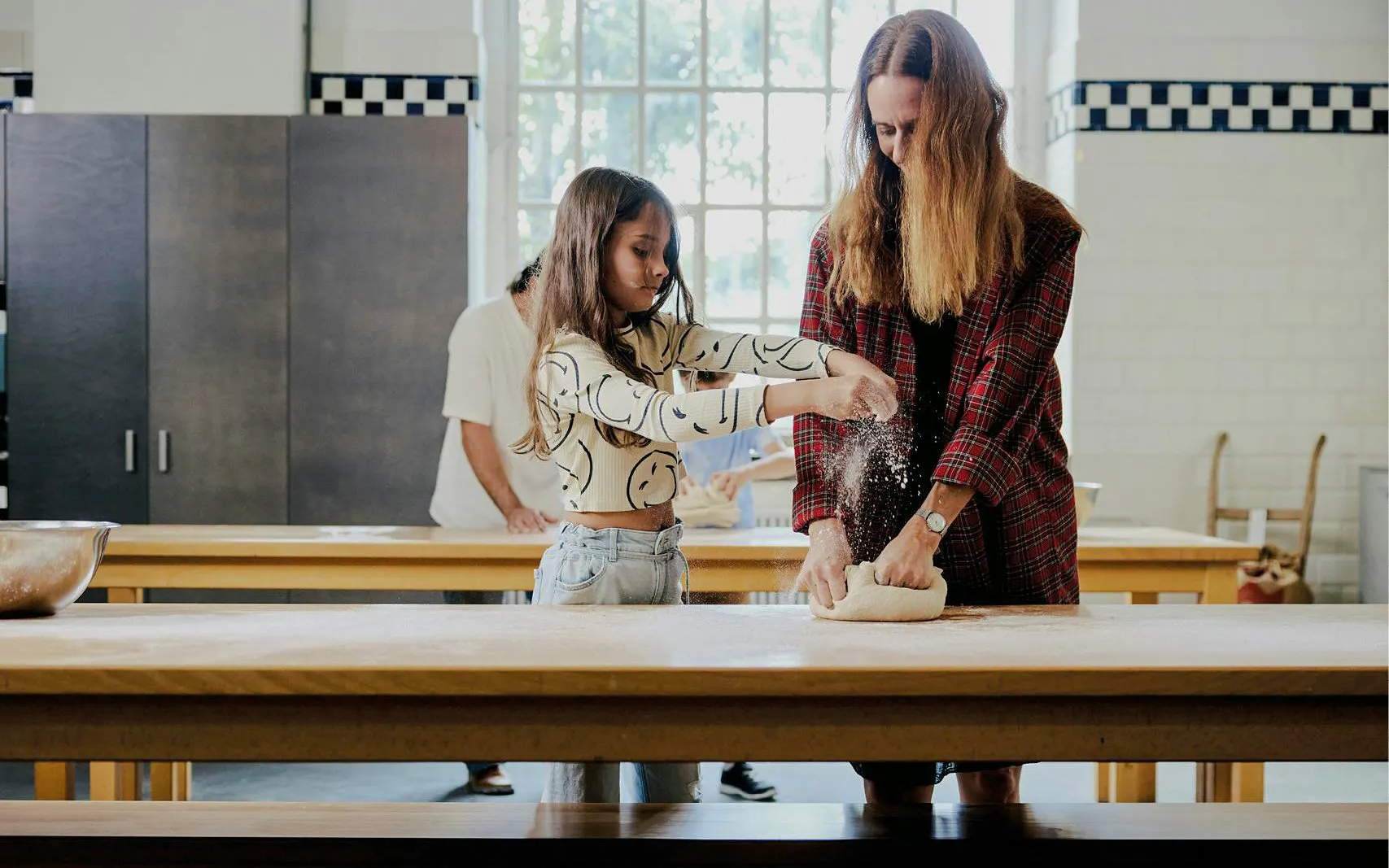Mom and child kneading dough in a cooking class.