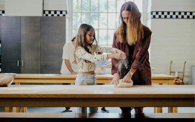 Mom and child kneading dough in a cooking class.