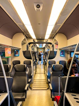 Interior of Malpensa Express train with passengers and luggage.