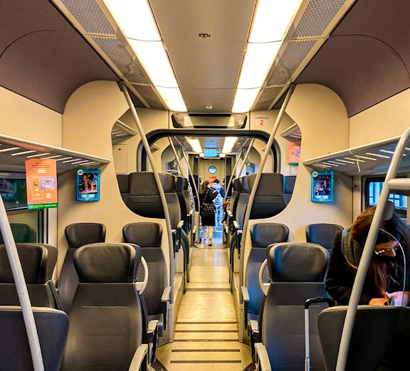 Interior of Malpensa Express train with passengers and luggage.