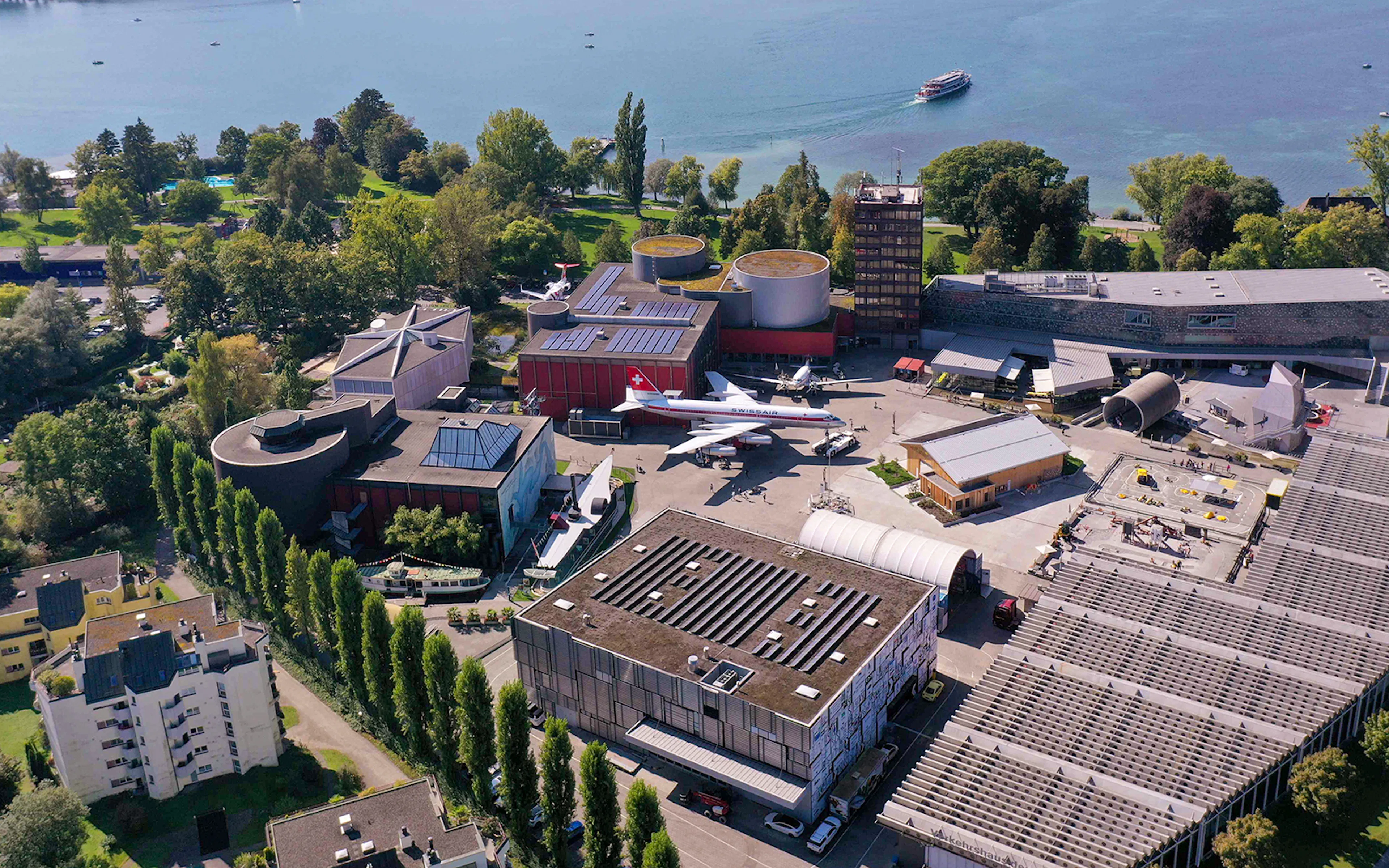 Aerial view of Swiss Museum of Transport in Lucerne with surrounding landscape.