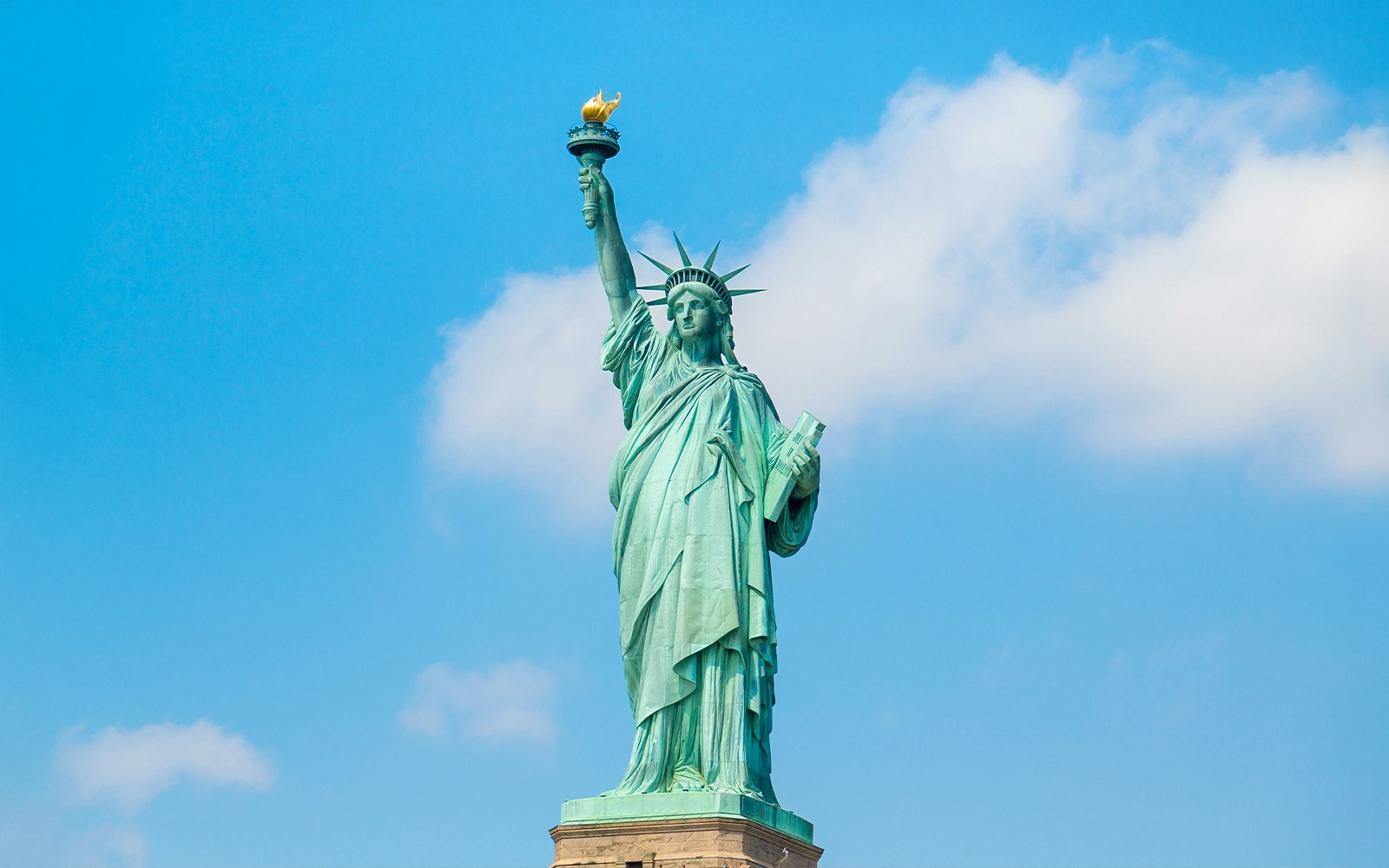 Statue of Liberty with New York City skyline in the background, viewed from a boat tour.