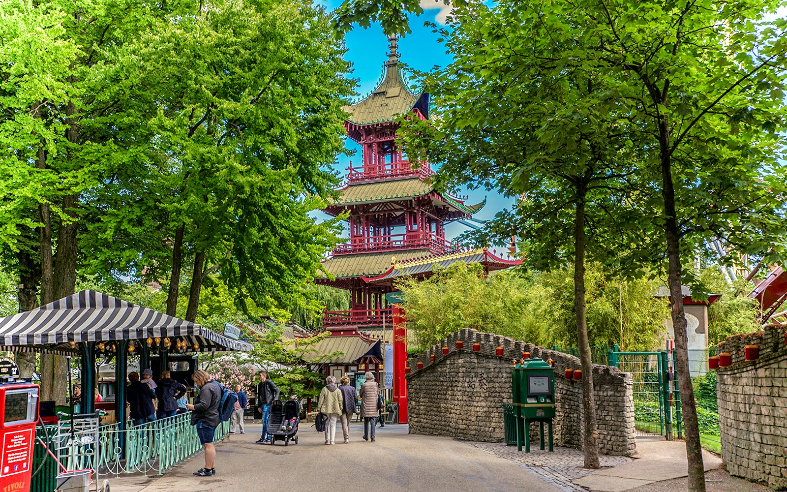 Pagoda in Tivoli Gardens, Copenhagen, surrounded by trees and visitors strolling nearby.