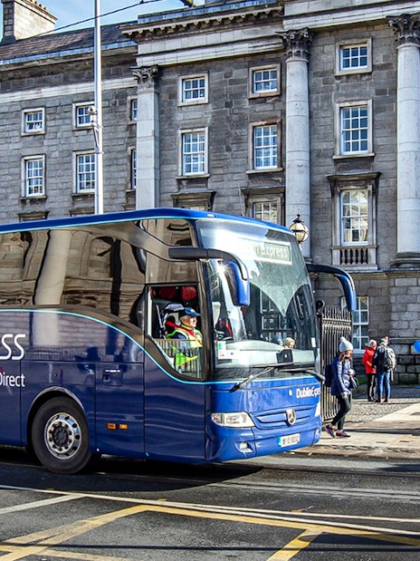 Dublin Express bus at Custom House Quay with historic building in background.