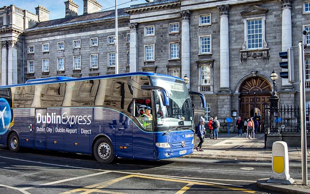 Dublin Express bus at Custom House Quay with historic building in background.