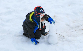 Child building a snowman at Valle Nevado.