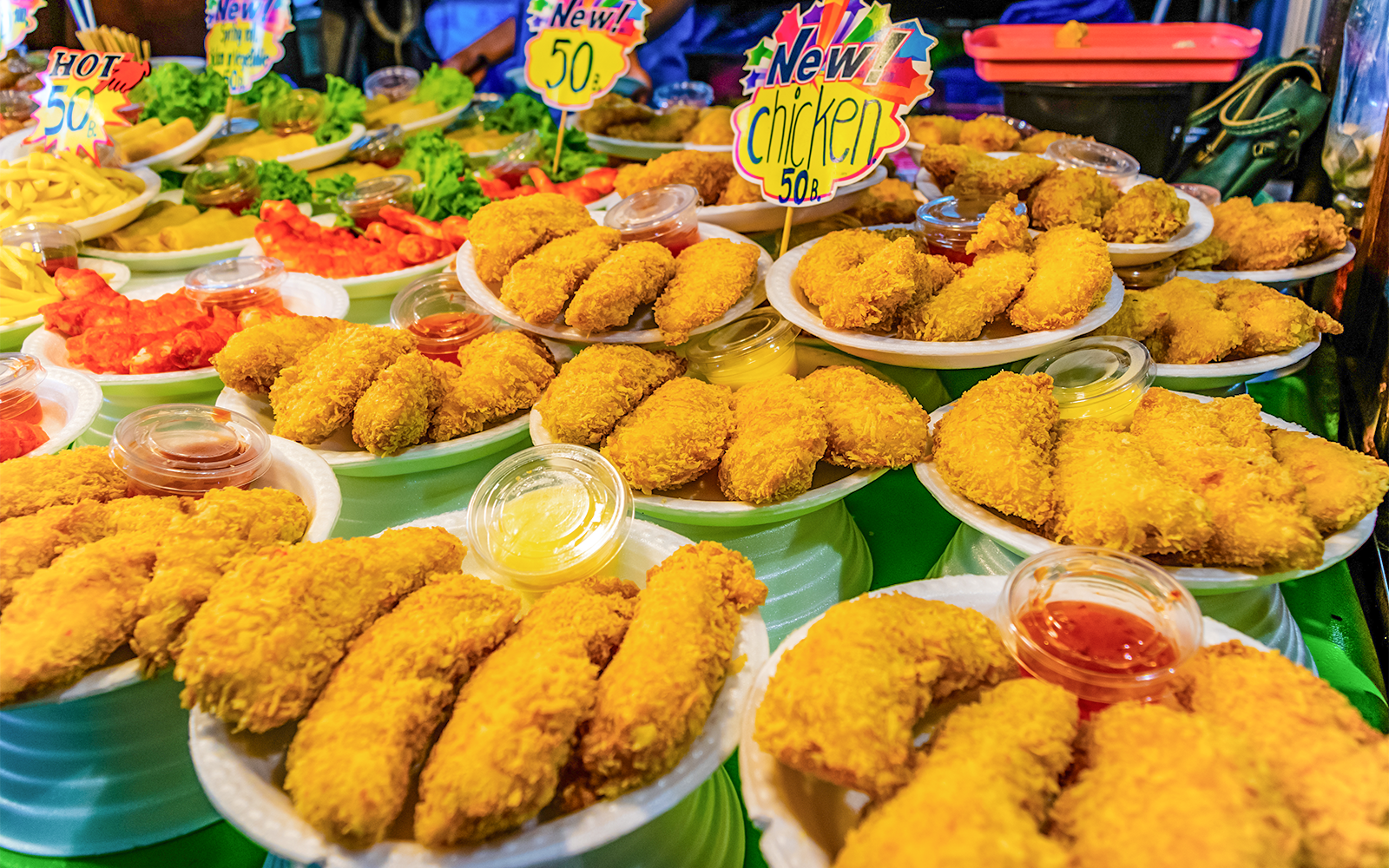 Fried chicken and sauces at a street food stall in Phuket Naka Market.