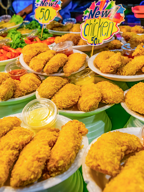 Fried chicken and sauces at a street food stall in Phuket Naka Market.