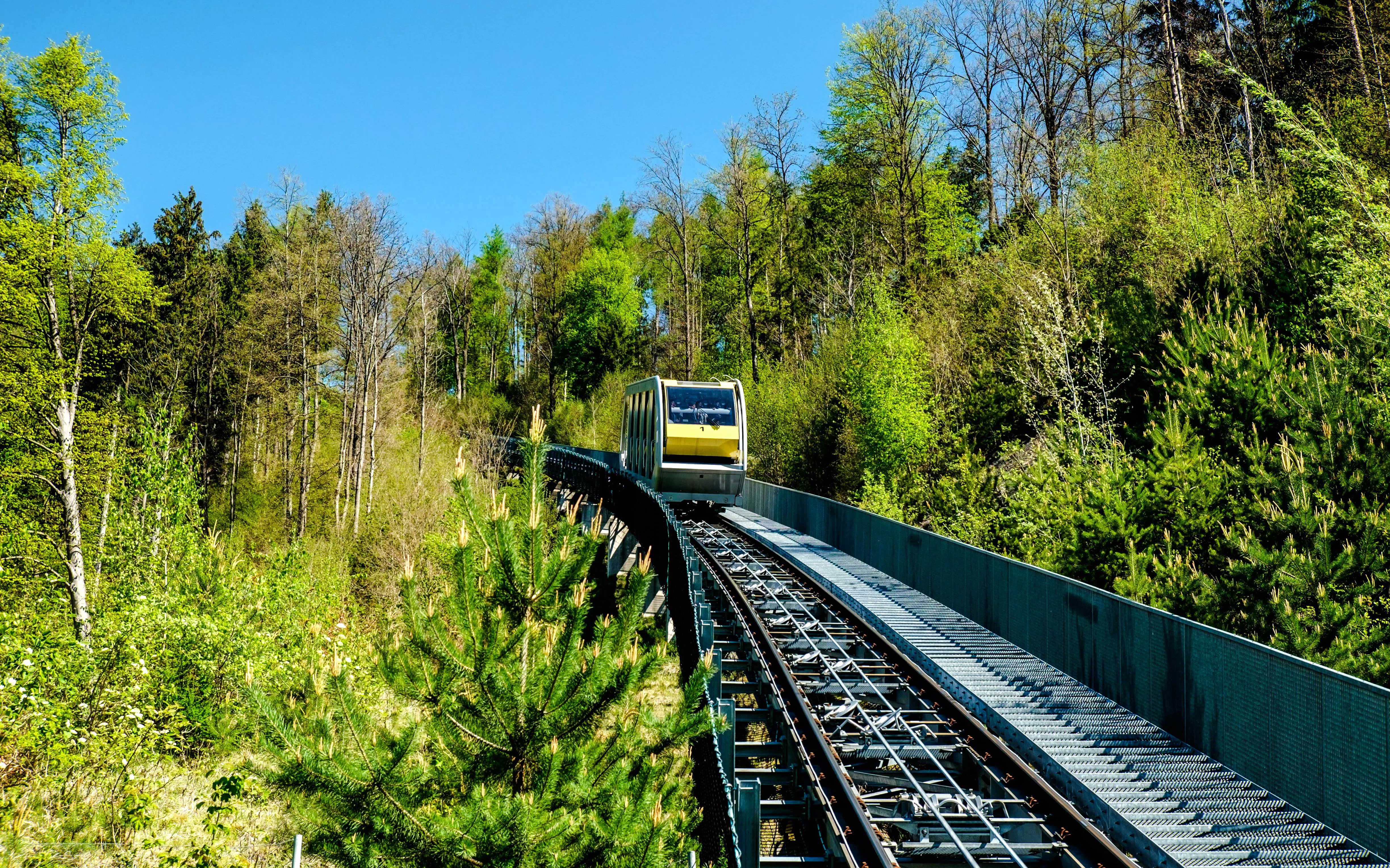 Hungerburgbahn funicular railway traveling through forested area in Innsbruck, Austria.