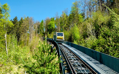 Hungerburgbahn funicular railway traveling through forested area in Innsbruck, Austria.