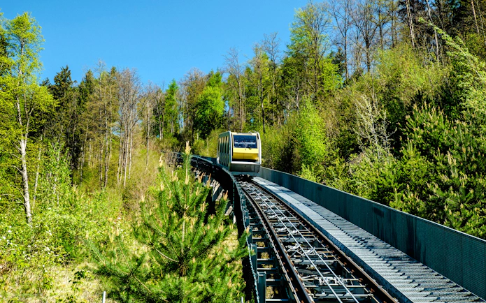 Hungerburgbahn funicular railway traveling through forested area in Innsbruck, Austria.