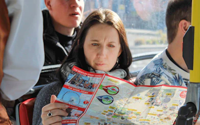 Woman reading map on Liverpool Hop On Hop Off city tour bus.