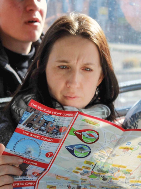 Woman reading map on Liverpool Hop On Hop Off city tour bus.