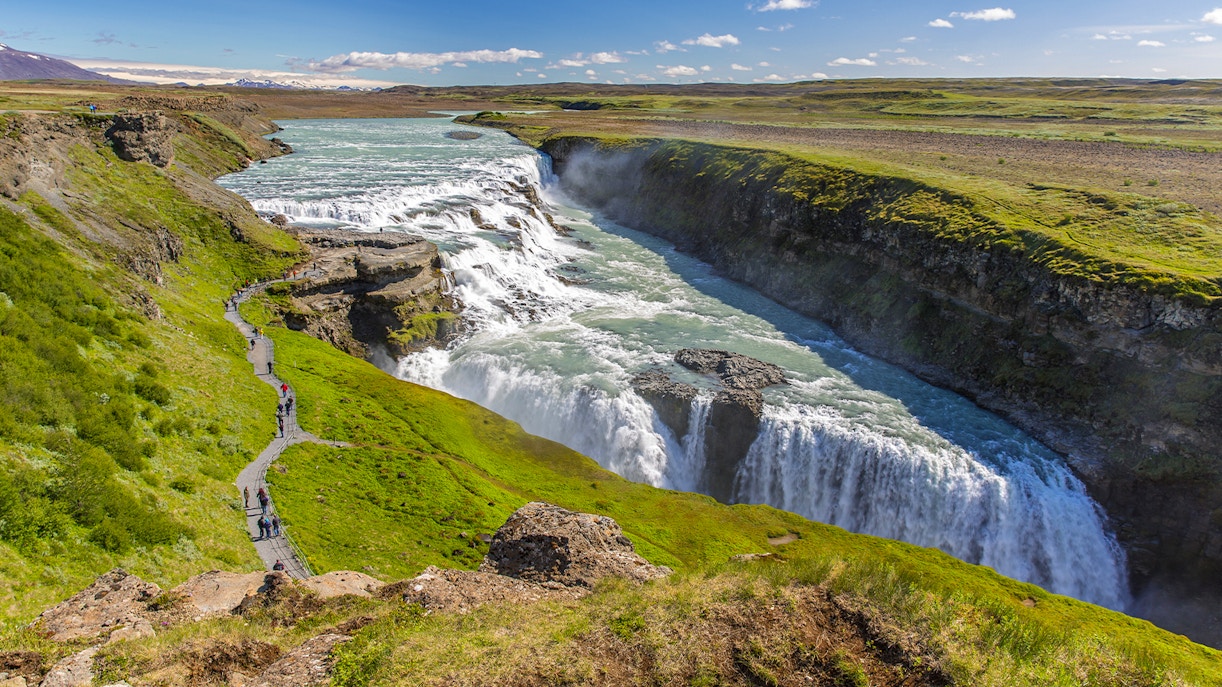 Gullfoss Falls cascading in tiers, surrounded by rugged Icelandic landscape.
