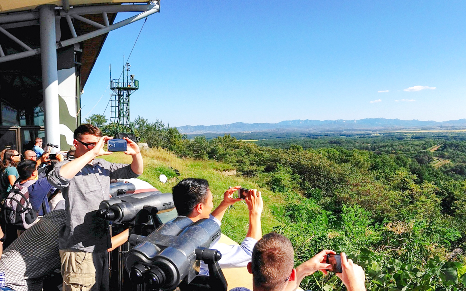 Visitors at observatory viewing landscape on Seoul to DMZ tour, South Korea.