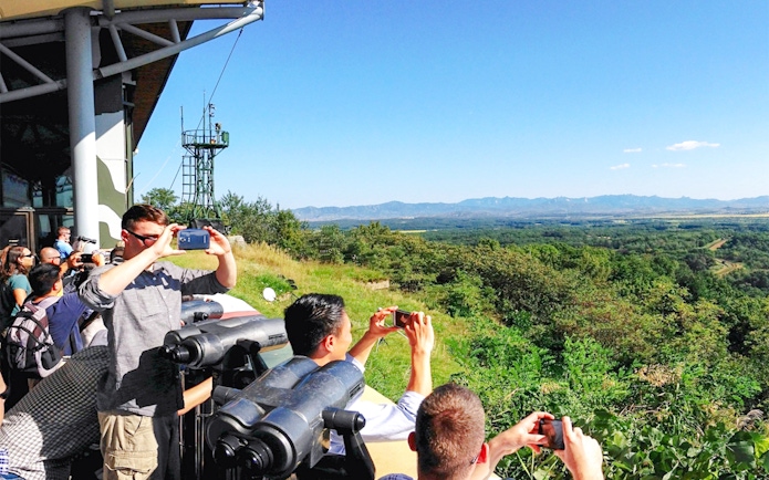 Visitors at observatory viewing landscape on Seoul to DMZ tour, South Korea.