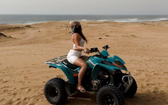 Person riding an ATV on sandy beach during Morocco road trip from Essaouira.
