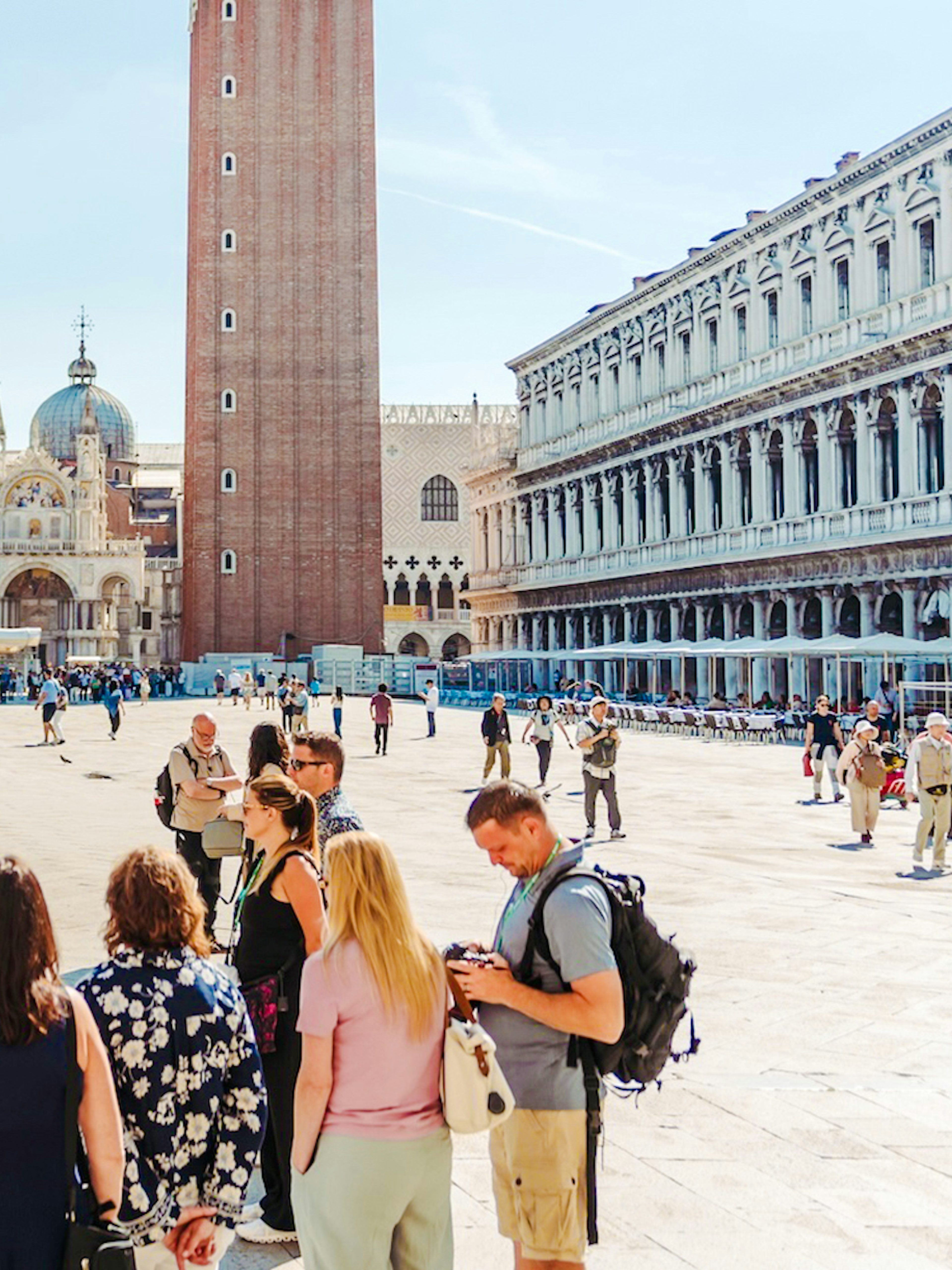 Tour group in Saint Mark's Square, Venice, with Basilica and Campanile in view.