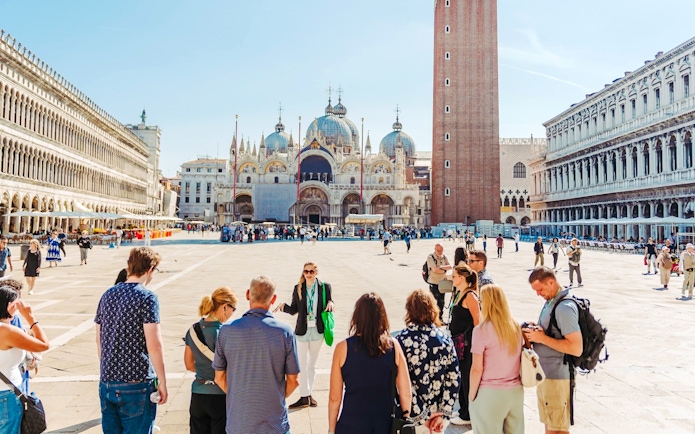 Tour group in Saint Mark's Square, Venice, with Basilica and Campanile in view.