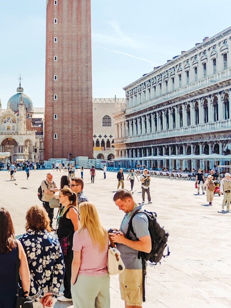 Tour group in Saint Mark's Square, Venice, with Basilica and Campanile in view.