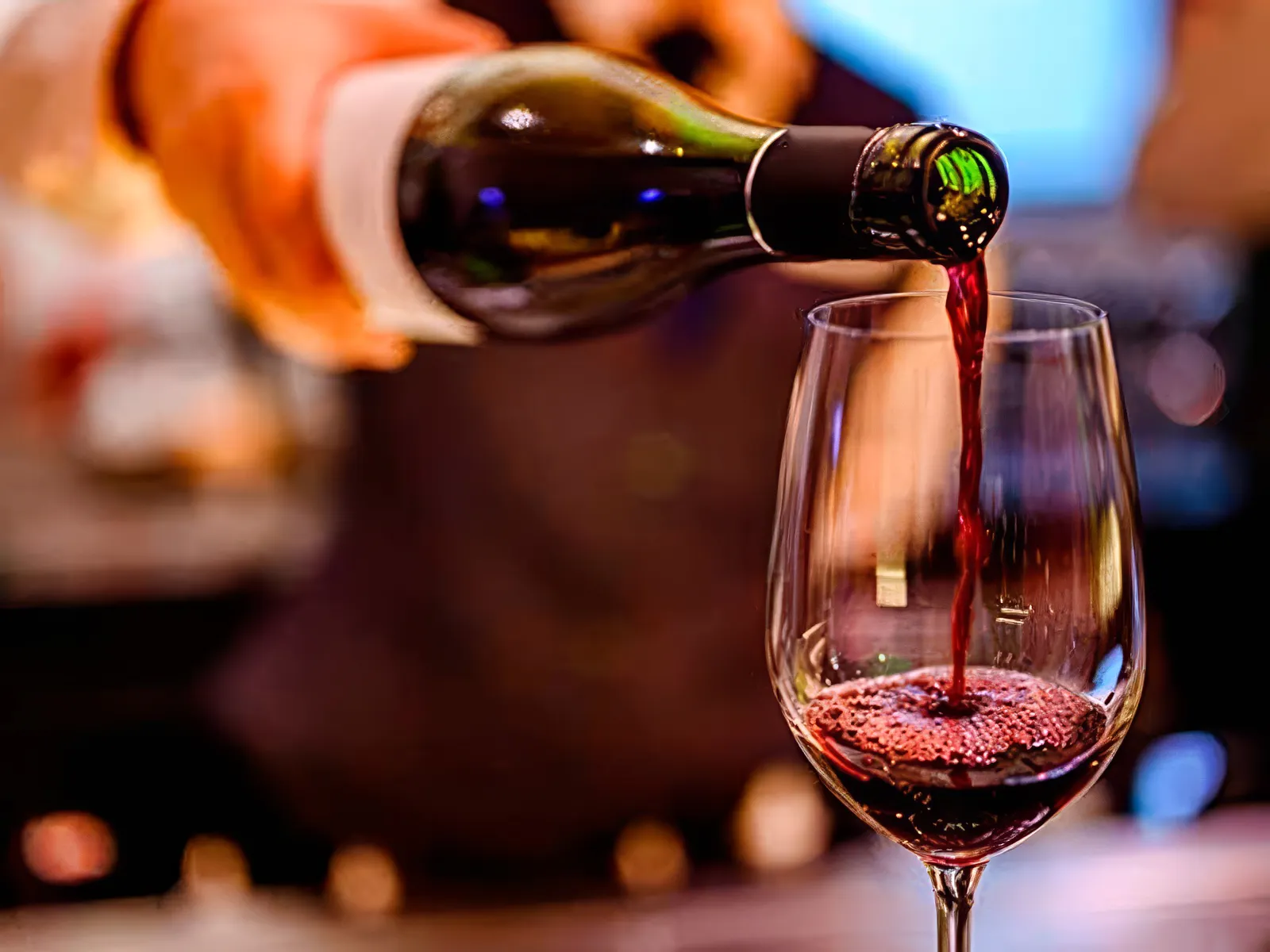 Pouring red wine into a glass at Homero Manzi Tango show dinner.
