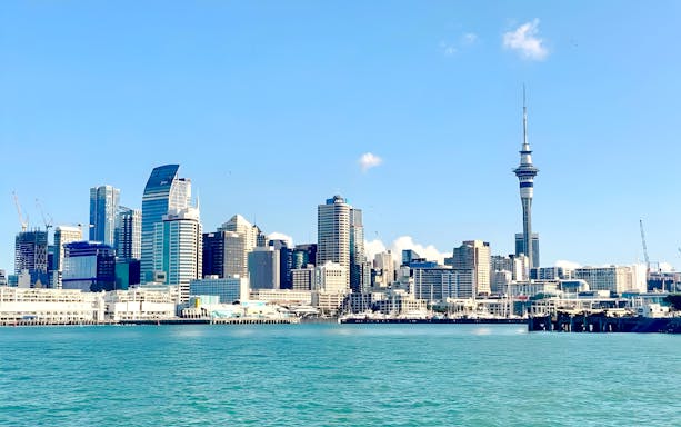 Auckland skyline with Sky Tower viewed from the harbor during a scenic cruise.