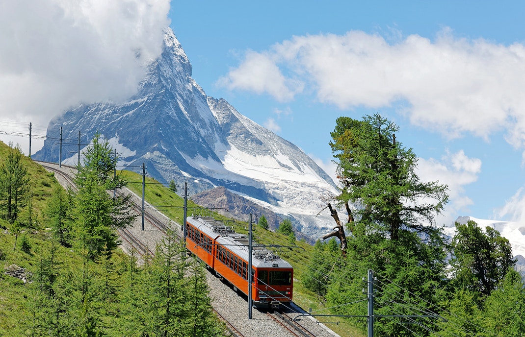 Gornergrat Railway ascending Swiss Alps with Matterhorn view.