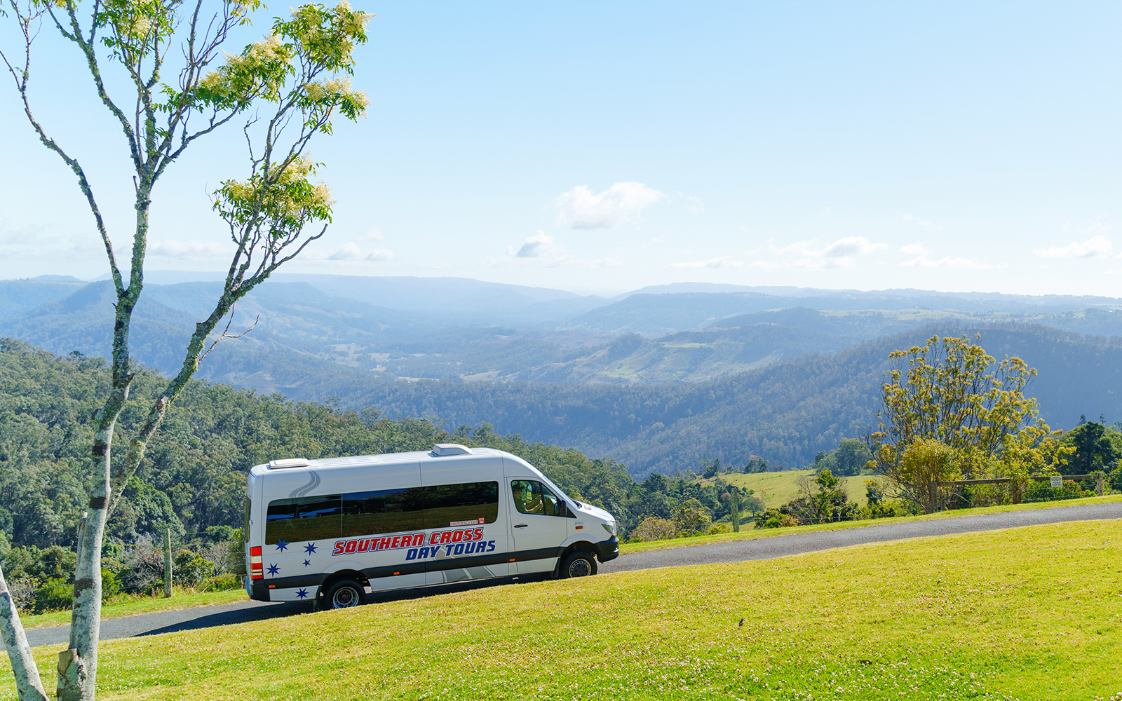 Van driving through Lamington National Park with scenic mountain views.