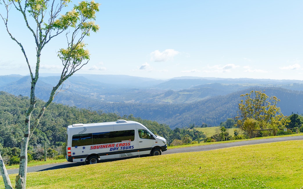 Van driving through Lamington National Park with scenic mountain views.