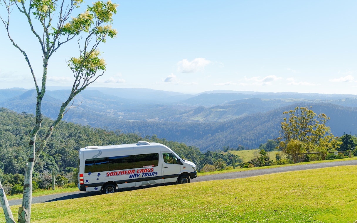 Van driving through Lamington National Park with scenic mountain views.