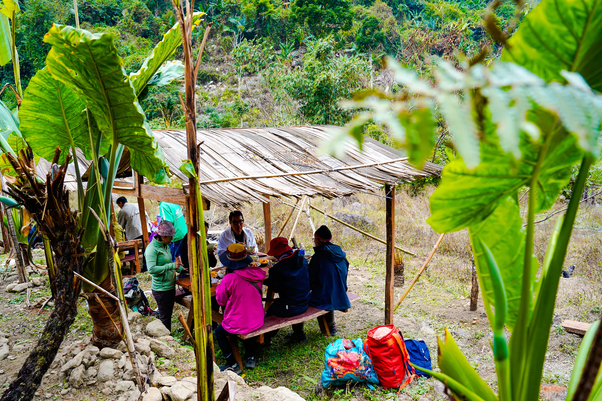 Group dining under bamboo shelter in Ba Be National Park, Vietnam.