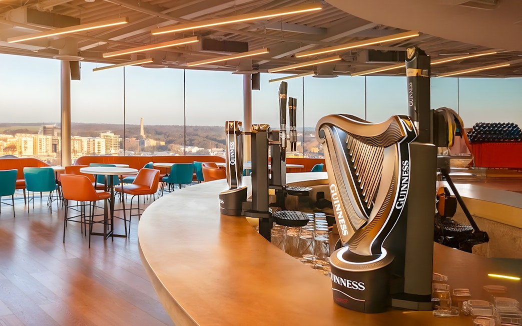 Guinness Storehouse Gravity Bar with city view and harp-shaped beer taps.