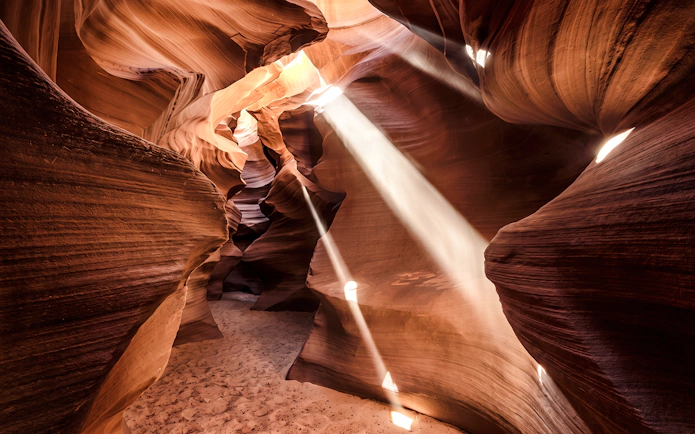 Sunlight beams through narrow sandstone walls in Secret Antelope Canyon.
