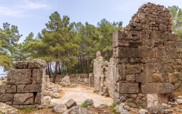 Ancient ruins surrounded by trees at Phaselis Bay, Turkey, on a pirate boat trip from Kemer.
