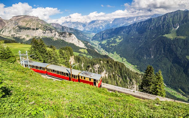 Train on Schynige Platte railway with views of Swiss Alps near Interlaken.