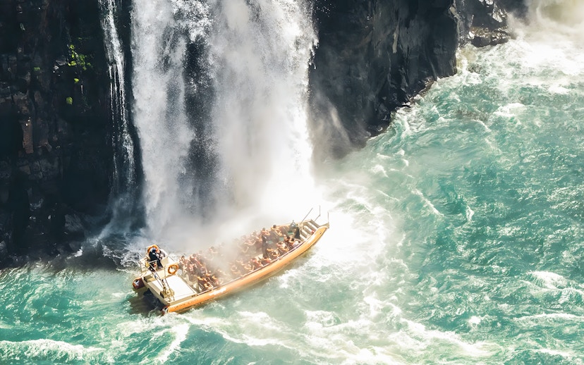 Tourists on a boat near waterfall at Iguazú Falls, Brazilian side.