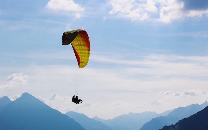 Paragliding over mountains in Interlaken, Switzerland.