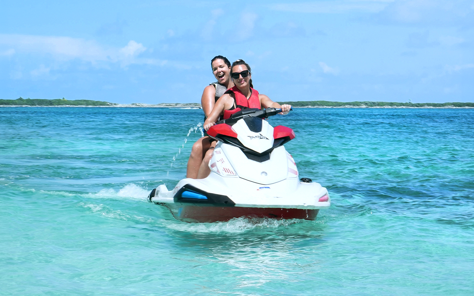 Jet skiing in Mansa Bay during a private island day trip.