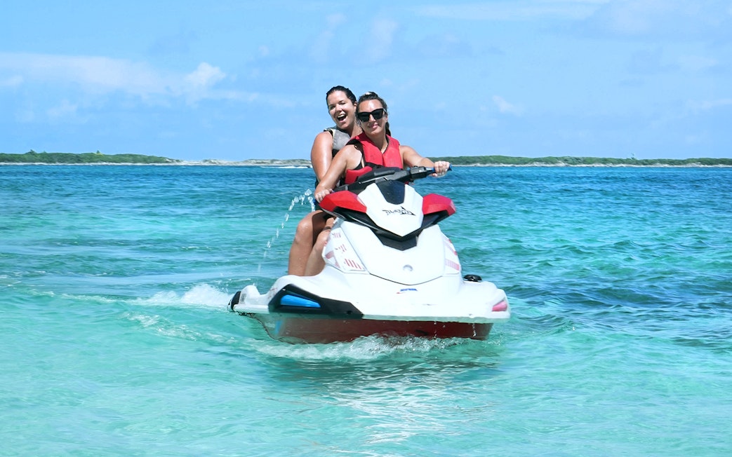 Jet skiing in Mansa Bay during a private island day trip.