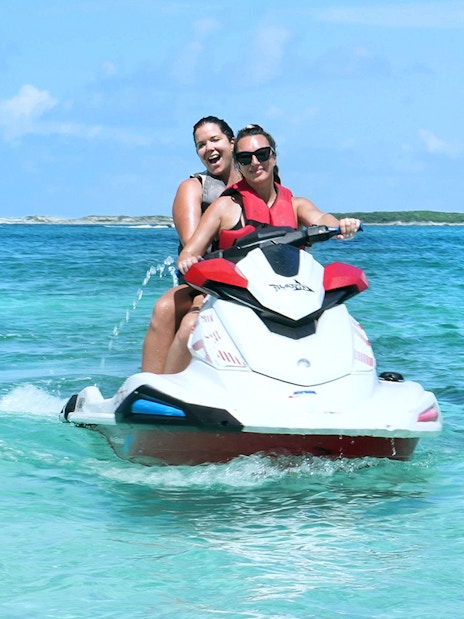 Jet skiing in Mansa Bay during a private island day trip.