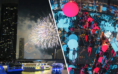 Fireworks over Chao Phraya River with illuminated cruise boats in Bangkok.